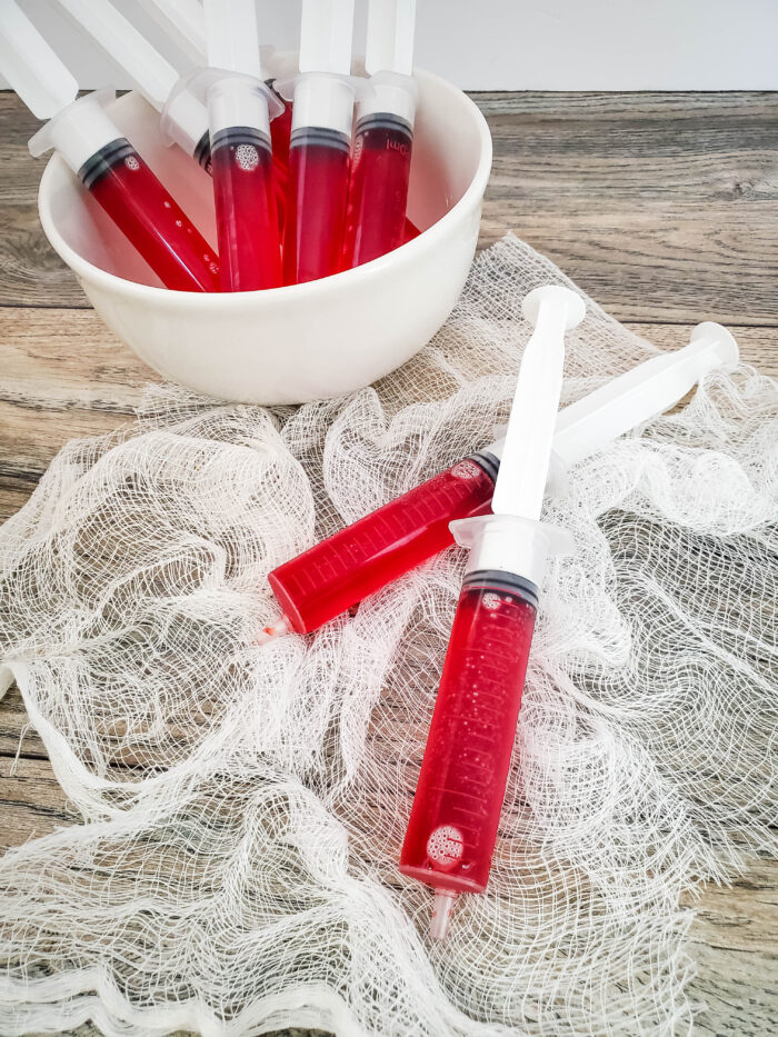 red jello syringe shots on white netting